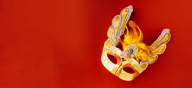 Happy Purim carnival. Carnival mask for Mardi Gras celebration isolated on red background banner design with copy space, jewish holiday, Purim in Hebrew holiday carnival ball, Venetian mask