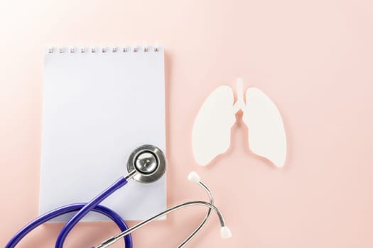 World TB Day. Top view lungs paper symbol, medical stethoscope and notebook paper on pastel pink background, lung cancer awareness, copy space concept of world tuberculosis day, banner background