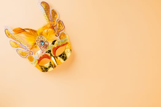 Happy Purim carnival decoration. Golden venetian ball mask isolated on pastel background, Jewish Purim and Mardi Gras in Hebrew, holiday background banner design with copy space, Masquerade party