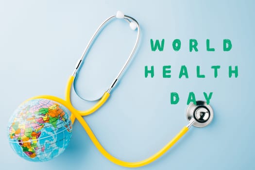 World Health Day. Yellow doctor stethoscope and world globe isolated on blue background, Save world day, Green Earth, Healthcare and medical concept