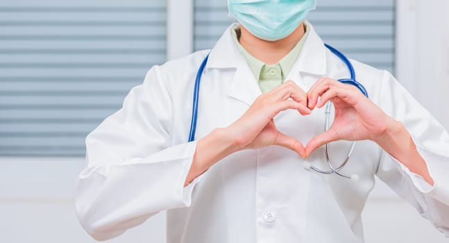 Doctor Day Concept. Doctor woman wearing uniform and stethoscope she making heart finger shape, Doctor's hand sign, Healthy medical heart, treatment of heart diseases by palms
