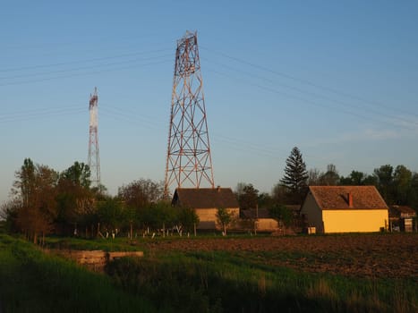 House and arable land next to the power line. Electrical network, power equipment system for the transmission of electricity by means of electric current. Negative effect of electromagnetic radiation.