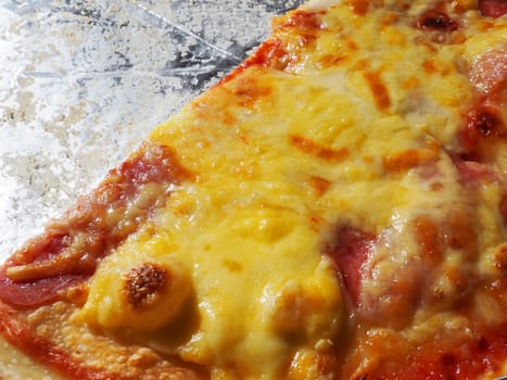 Pizza with tomatoes and cheese in a cardboard box and aluminum foil. Delicious pizza close up. Courier delivery of food to your home. Ordering pizza. Traditional Italian round yeast cake with filling.