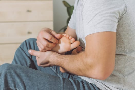 Dad holds and tickles feet of kid. Boy plays with his father. Family having fun at home