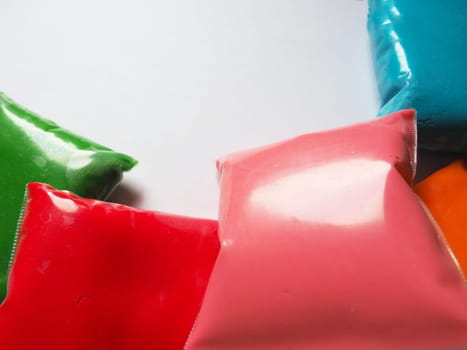 Colorful kid's plasticine on white background, Colorful dough modeling clay. Packing of colored soft plasticine in plastic bags. Copy space.