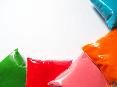 Colorful kid's plasticine on white background, Colorful dough modeling clay. Packing of colored soft plasticine in plastic bags. Copy space.
