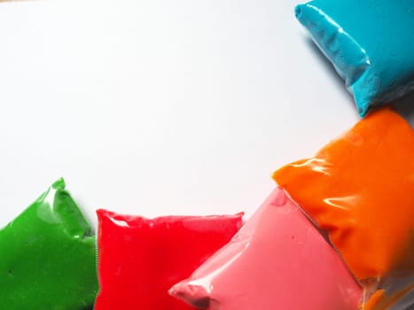 Colorful kid's plasticine on white background, Colorful dough modeling clay. Packing of colored soft plasticine in plastic bags. Copy space.