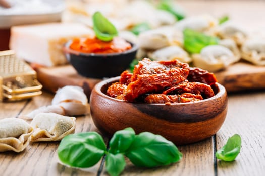 Home cooking - raw tortellini pasta with tomato pesto and sun-dried tomatoes and basil