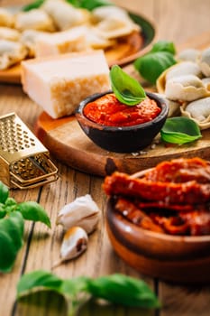 Home cooking - raw tortellini pasta with tomato pesto and sun-dried tomatoes and basil
