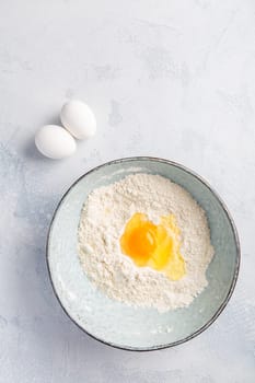 Flour with egg in bowl - cooking and baking ingredients
