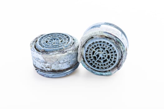 Dirty faucet aerator with limescale, calcified shower water tap with lime scale in bathroom, close up, isolated on white