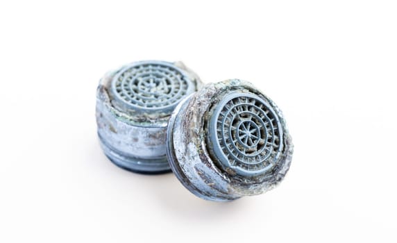 Dirty faucet aerator with limescale, calcified shower water tap with lime scale in bathroom, close up, isolated on white