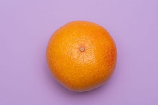 Orange Grapefruit isolated on a light purple background, top view
