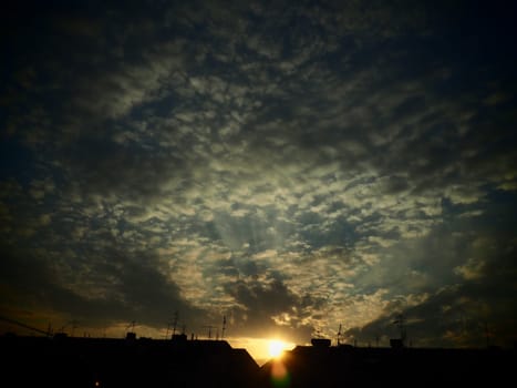 Black, green and yellow sunset sky cloud. Dramatic sunset sky. Wonderful sunset. Clouds in the evening sky. The sun's rays pierce the clouds. Beautiful landscape. The sun goes down. Vignetting