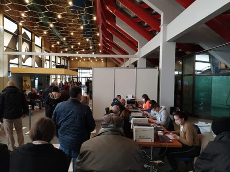 Sremska Mitrovica, Serbia. March 13, 2021 Covid-19 vaccination. Senior patient receiving coronavirus vaccination. Nurses record people data. People in protective masks waiting for the vaccine