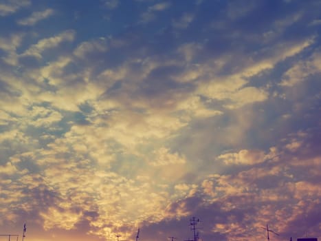 Beautiful, pink and yellow sunset in the sky. The clouds are colored by the low rays of the sun. Blue sky. Wonderful landscape