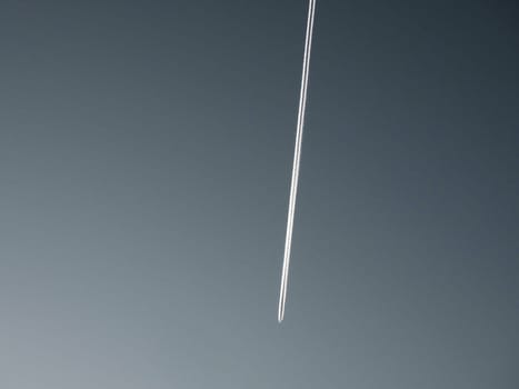 The exhaust trail behind a large aircraft high in the atmosphere.