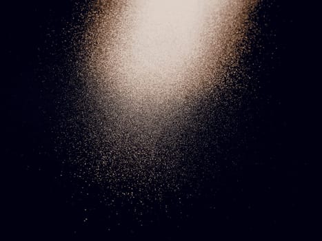 bokeh and beam on a black background. Blurred glow from above on a dark surface. Night or space theme. Bokeh for the holiday. Abstract background. Glare, ray and light shine from above. Sepia.