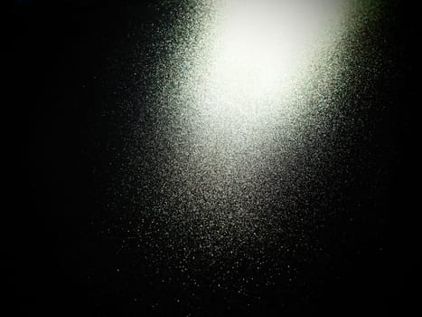 bokeh and beam on a black background. Blurred glow from above on a dark surface. Night or space theme. Bokeh for the holiday. Abstract background. Glare, ray and light shine from above