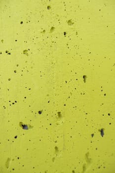 Detail of old cement wall painted yellow, decoration on the street
