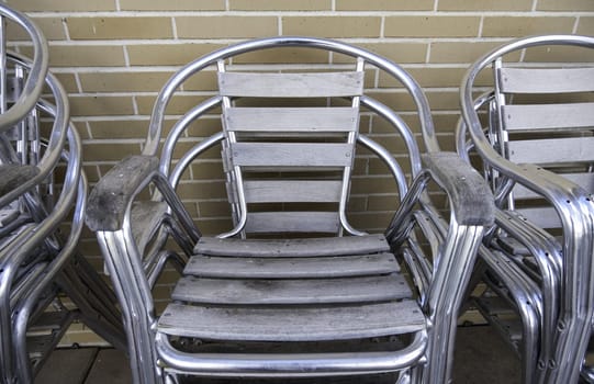 Detail of shiny metal chairs on a terrace of a bar in the city