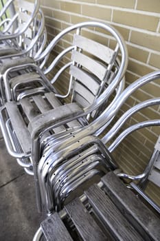 Detail of shiny metal chairs on a terrace of a bar in the city