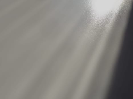 Diagonal rays of light on a gray background. Blurred abstract background light effect, light leaks. Side surface illumination. Small sparks and glow. Shine, glint or glare. Right top left down.