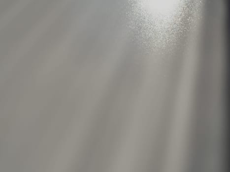 Diagonal rays of light on a gray background. Blurred abstract background light effect, light leaks. Side surface illumination. Small sparks and glow. Shine, glint or glare. Right top left down.