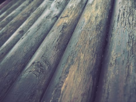 A construction log for use in construction without longitudinal sawing. Round timber assortment. Fragment of the construction of rounded wooden logs. The effect of moisture on wood