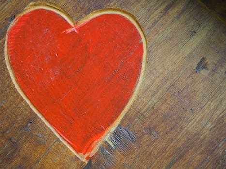 The shape of a heart carved with a knife on a wooden surface and painted in a bright red. A symbol of love and fidelity. Postcard or picture for congratulations or confessions on Valentines Day