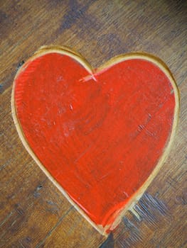 The shape of a heart carved with a knife on a wooden surface and painted in a bright red. A symbol of love and fidelity. Postcard or picture for congratulations or confessions on Valentines Day