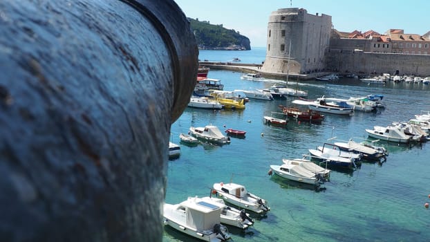 Dubrovnik, Croatia, 08.14. 2022 City port summer tourist attraction. Tourists walk, get into boats and ships and go on boat trips. Adriatic Sea. Travel. Cannon muzzle. Private boats of local citizens