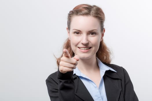 A young pretty woman in a blazer points her finger
