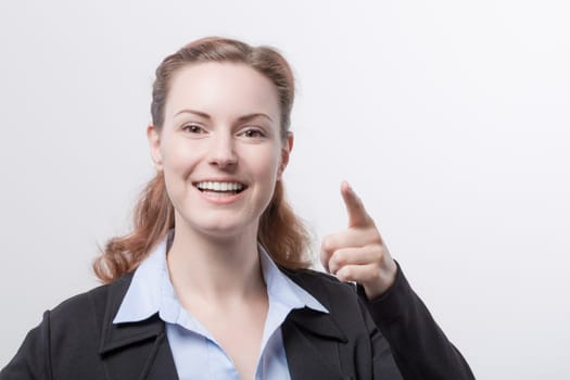 A young pretty woman in a blazer points her finger