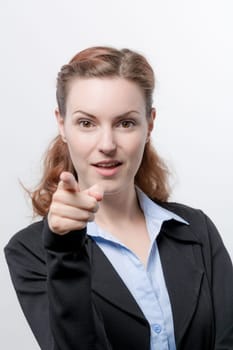 A young pretty woman in a blazer points her finger