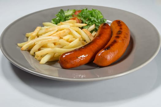 Sausage and French Fries on a plate with white background.