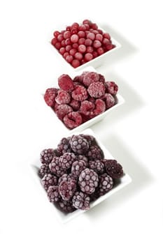 Three bowls of different frozen berries