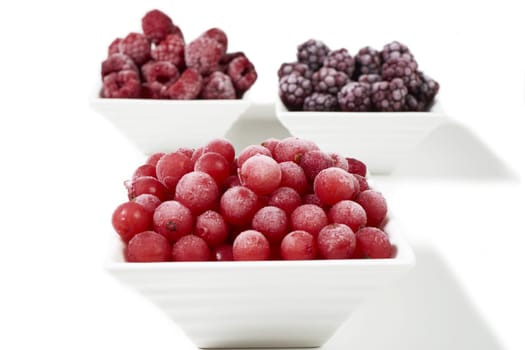 Three bowls of different frozen berries