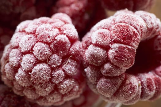 Macro intake of frozen raspberries with ice crystals