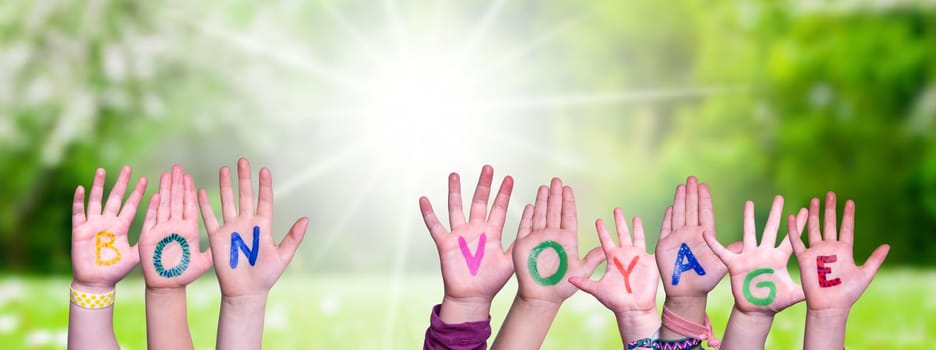 Children Hands Building Colorful French Word Bon Voyage Means Have A Good Trip. Sunny Green Grass Meadow As Background.