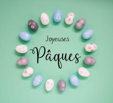 Flat Lay With French Text Joyeuses Paques Means Happy Easter. Easter Egg Arrangement, Decoration And Ornament. Light Green Paper Background
