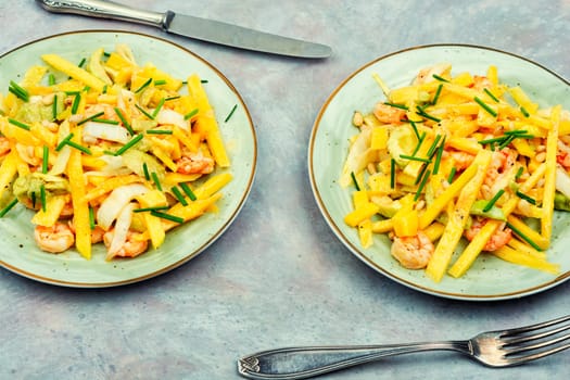 Delicious salad of mango, avocado, shrimp and pine nuts. Food background