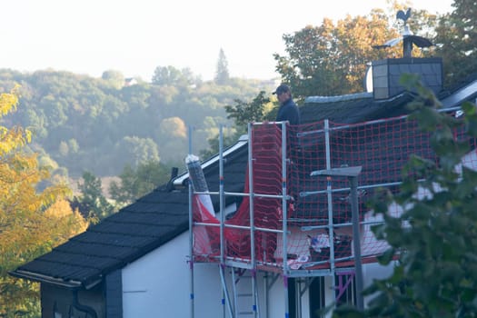 HEILIGENHAUS, NRW, GERMANY - OKTOBER 06, 2022:.Heiligenhaus, Nrw, Germany - Oktober 06, 2022:.Closeup of house roof top covered with ceramic shingles. Tiled covering of building