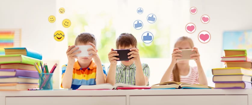 Children sitting in the room with smart phones. Pupils surfing at school.