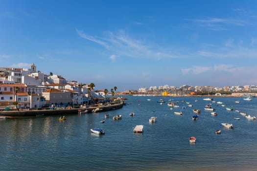 Ferragudo, Portugal - August 25, 2022 - View of the white town with boats moored in the foreground, Ferragudo, Algarve, Portugal, Europe
