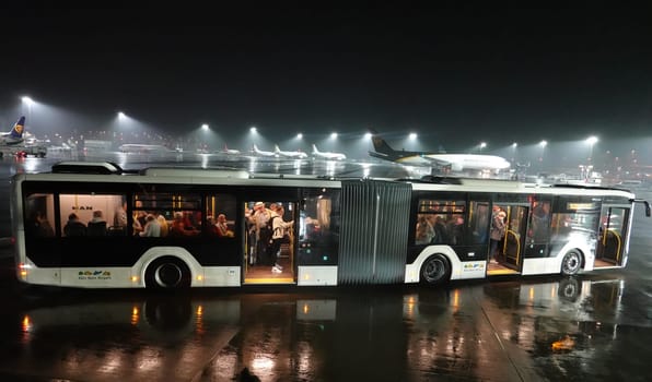 Shuttle-Bus holt Flugpasagiere an einem Aussenparkplatz, im Hitergrund zahlreiche Transportmaschinen, Konrad-Adenauer-Flughafen, Nordrhein-Westfalen, Deutschland, Köln