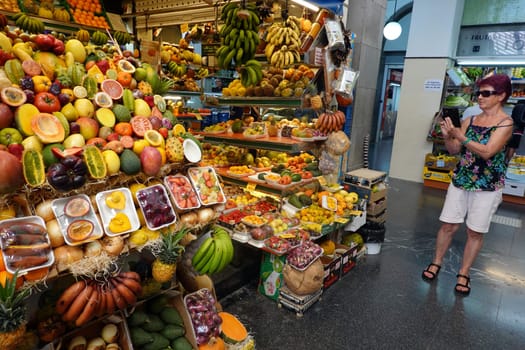 Touristin fotografiert überwätigendes Obst- und Gemüseangebot in der Markthalle Mercado de Vegueta, Gran Canaria, Spanien, Las Palmas