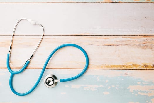 Top view blue medical stethoscope on wooden background with copy space for you text, Doctor equipment, healthcare and medical, Doctor Day and World cancer day Concept