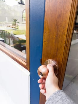 Hand on metal door holder, stock photo