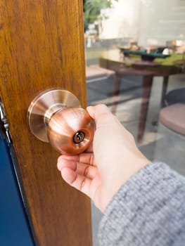 Hand on metal door holder, stock photo